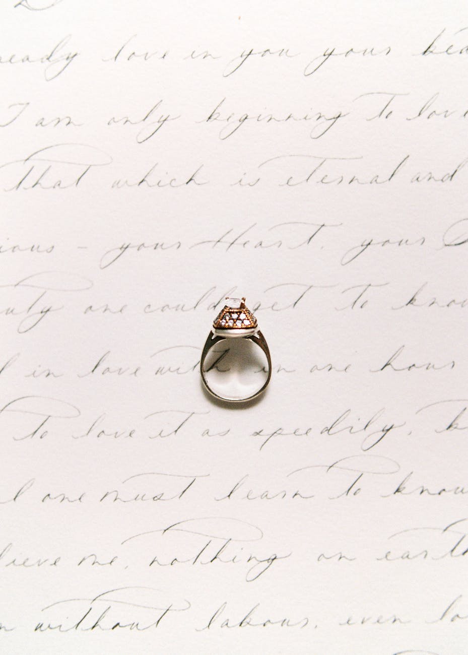 diamond ring on top of white sheet of paper with handwriting